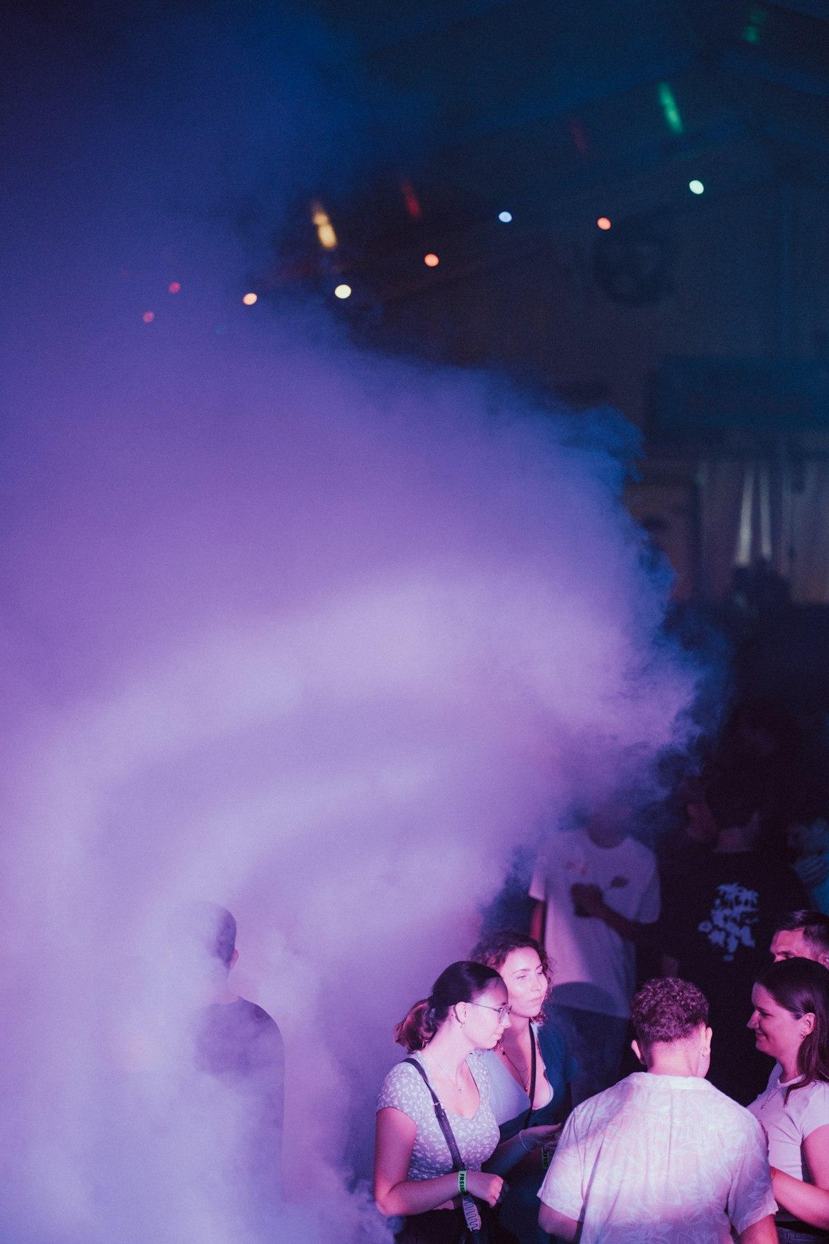 Fog rolling across a packed dance floor
