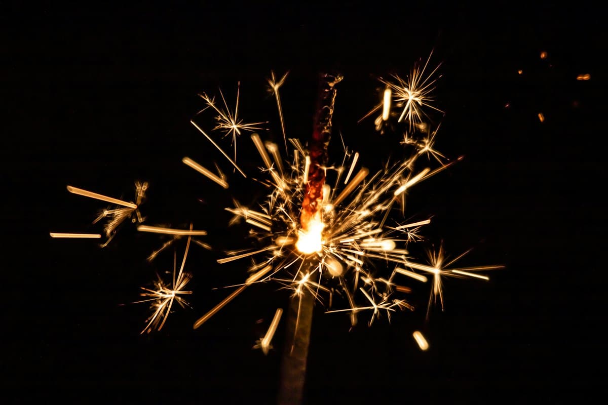 Close-up of gold sparks bursting in the dark
